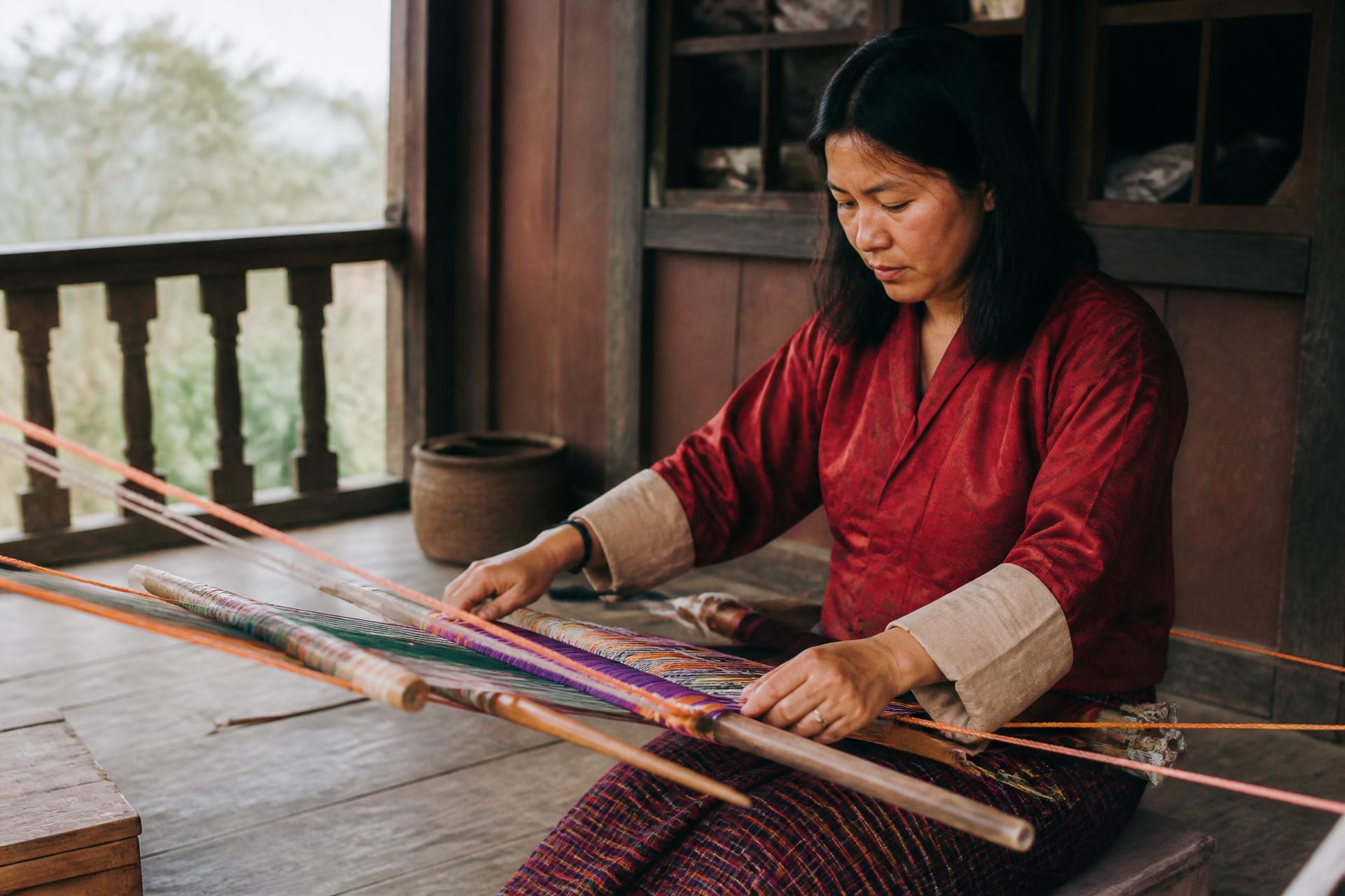 A Bhutanese craftsman weaving at a traditional loom